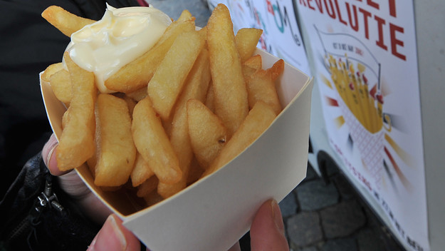 woman holds French fries (fried chips)