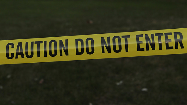 Police tape stretches across the front yard of the Lanza residence