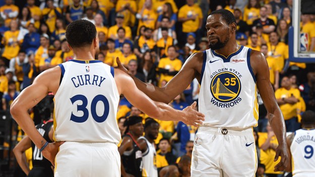 Stephen Curry and Kevin Durant high five while still teammates on Golden State.