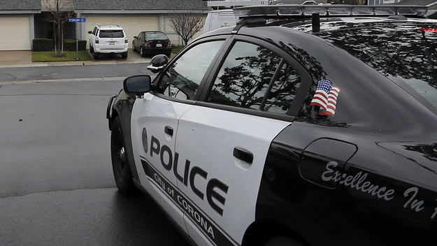 Police officers patrol a neighborhood in Corona hours