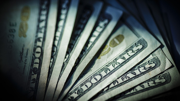 In this Photo Illustration Dollar bills lying on a table.