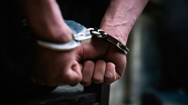 Stock image of handcuffed wrists.