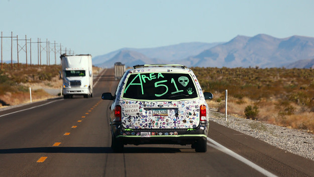 A car drives with 'Area 51' written on the back