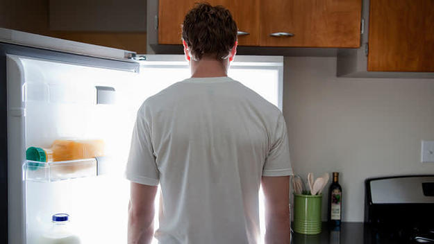 Man stares at fridge contents