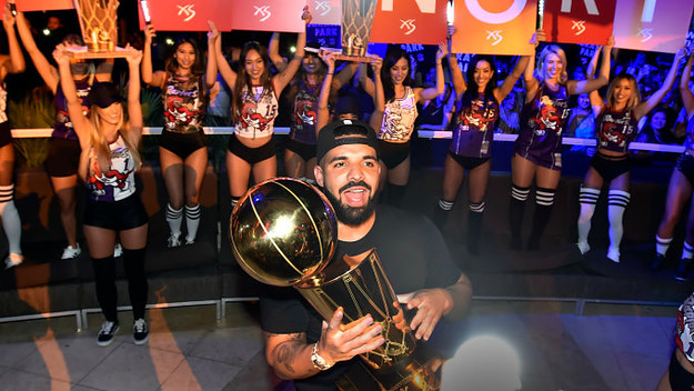 Drake carries the Larry O'Brien NBA Championship Trophy