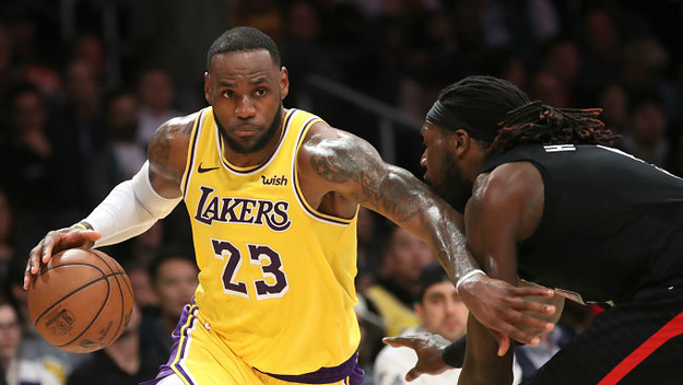 LeBron James #23 of the Los Angeles Lakers dribbles past Montrezl Harrell