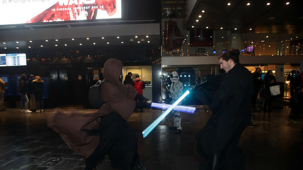 Fans in costume duel with lightsabers