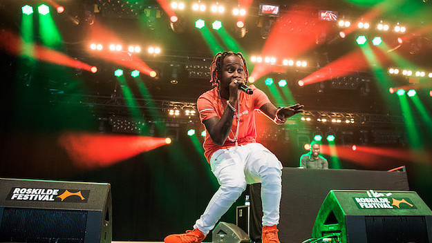 Popcaan performs on stage.