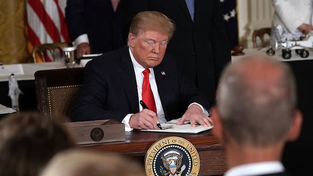 Donald Trump signs an executive order during a meeting of the National Space Council.