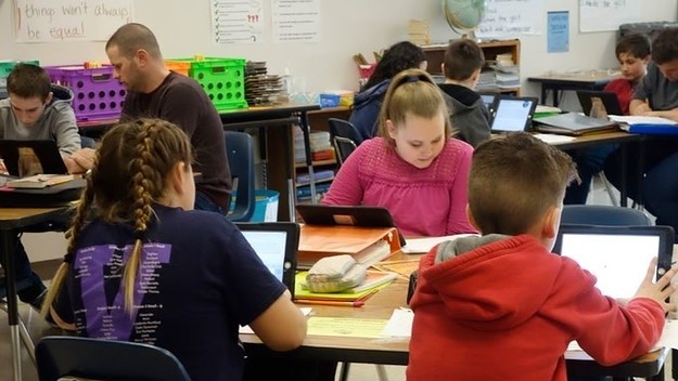 Students and teacher working in a classroom Wellsville, New York