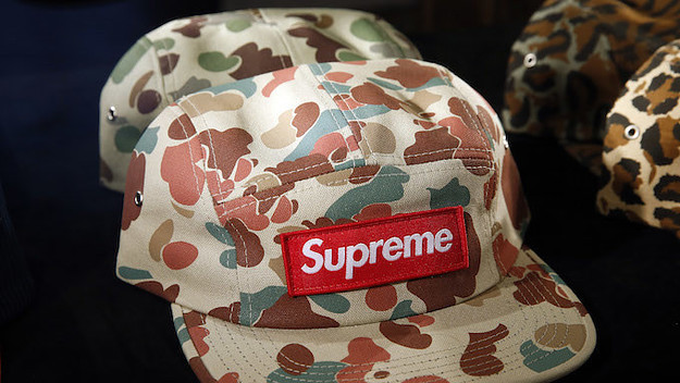 A cap entitled 'Duck Camo' by Supreme is displayed during exhibition.