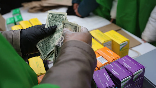 Money is collected as Girl Scouts sell cookies.