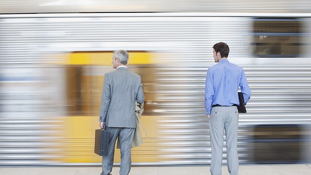 Two men waiting for train on platform.