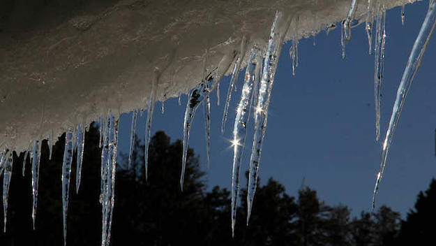 Icicles hang from a roof top.