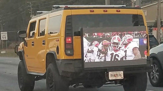 A cocky Georgia fan plays the SEC Championship Game on the back of his Hummer.