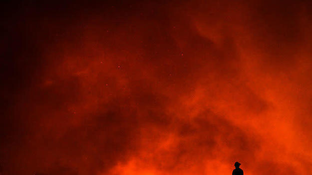 A firefighter watches as a California wildfire rages.