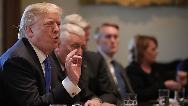 Donald Trump presiding over a meeting about immigration.