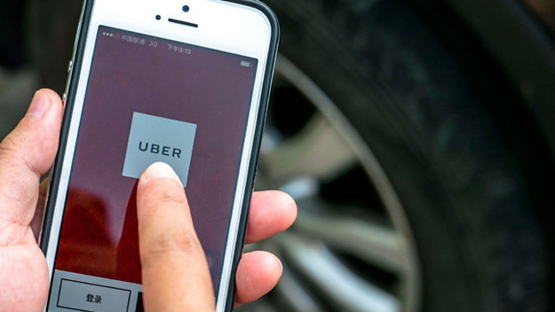 Hand holding a smart phone with Uber App.