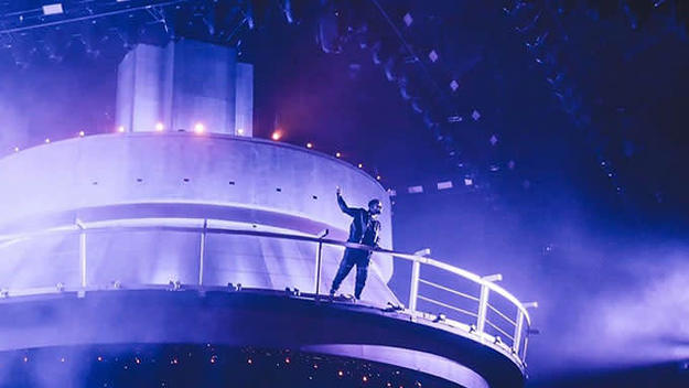 Drake stands atop a giant CN tower replica in front of the OVO Fest crowd.
