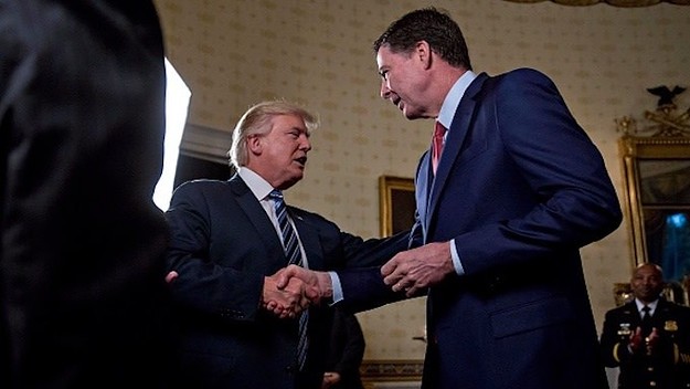 Donald Trump (C) shakes hands with James Comey