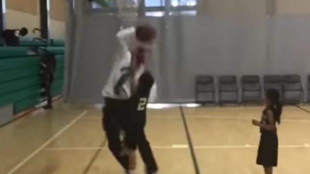 Youth basketball coach blocks his own player.