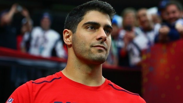 Jimmy Garoppolo stands on the sideline.