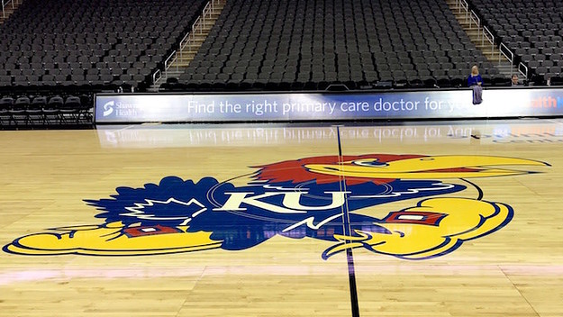 Kansas Jayhawks logo as it appears on a basketball court.