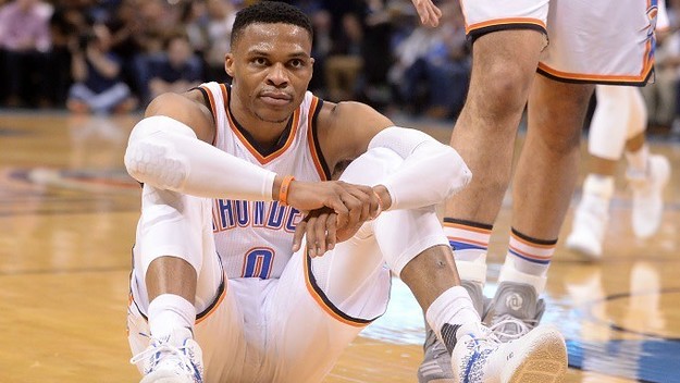 Russell Westbrook sits on the floor during a Thunder game.