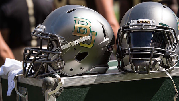 Two Baylor football helmets sitting on the sidelines.