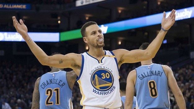 Steph Curry raises his arms during a game.