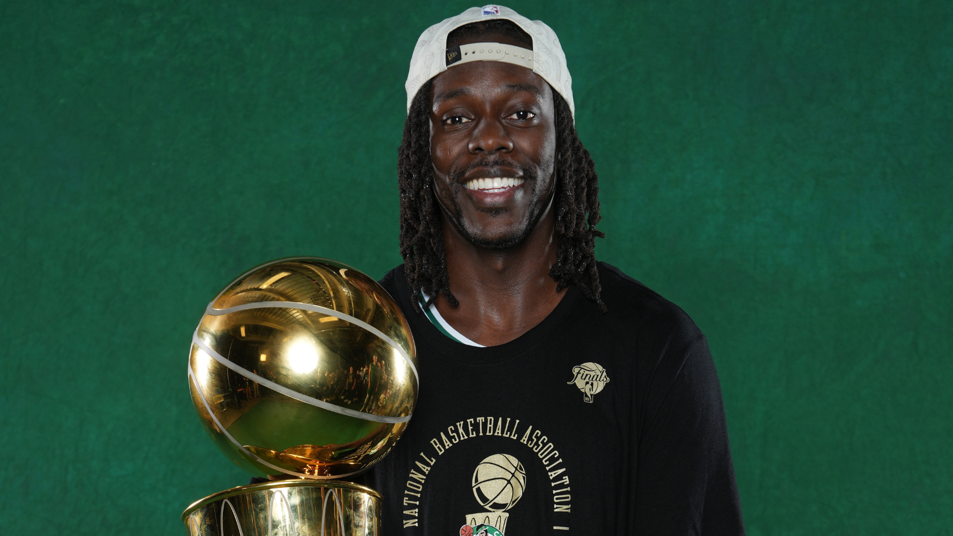 Jrue Holiday holding the Larry O'Brien trophy.