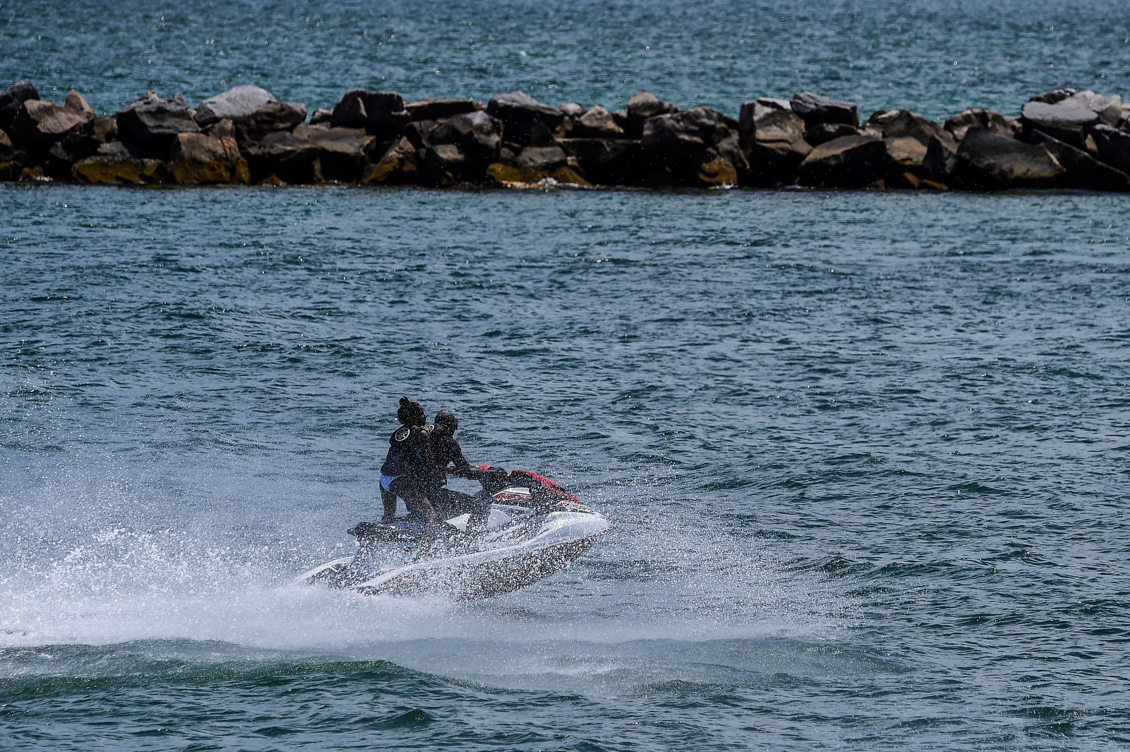 People ride on a jet-ski ahead of the July 4th holiday weekend in Miami Beach, Miami, on July 3, 2020. - Florida and other so-called "Sun Belt" states have been forced to re-shut restaurants, bars and beaches as the nation braces for the July 4 weekend.