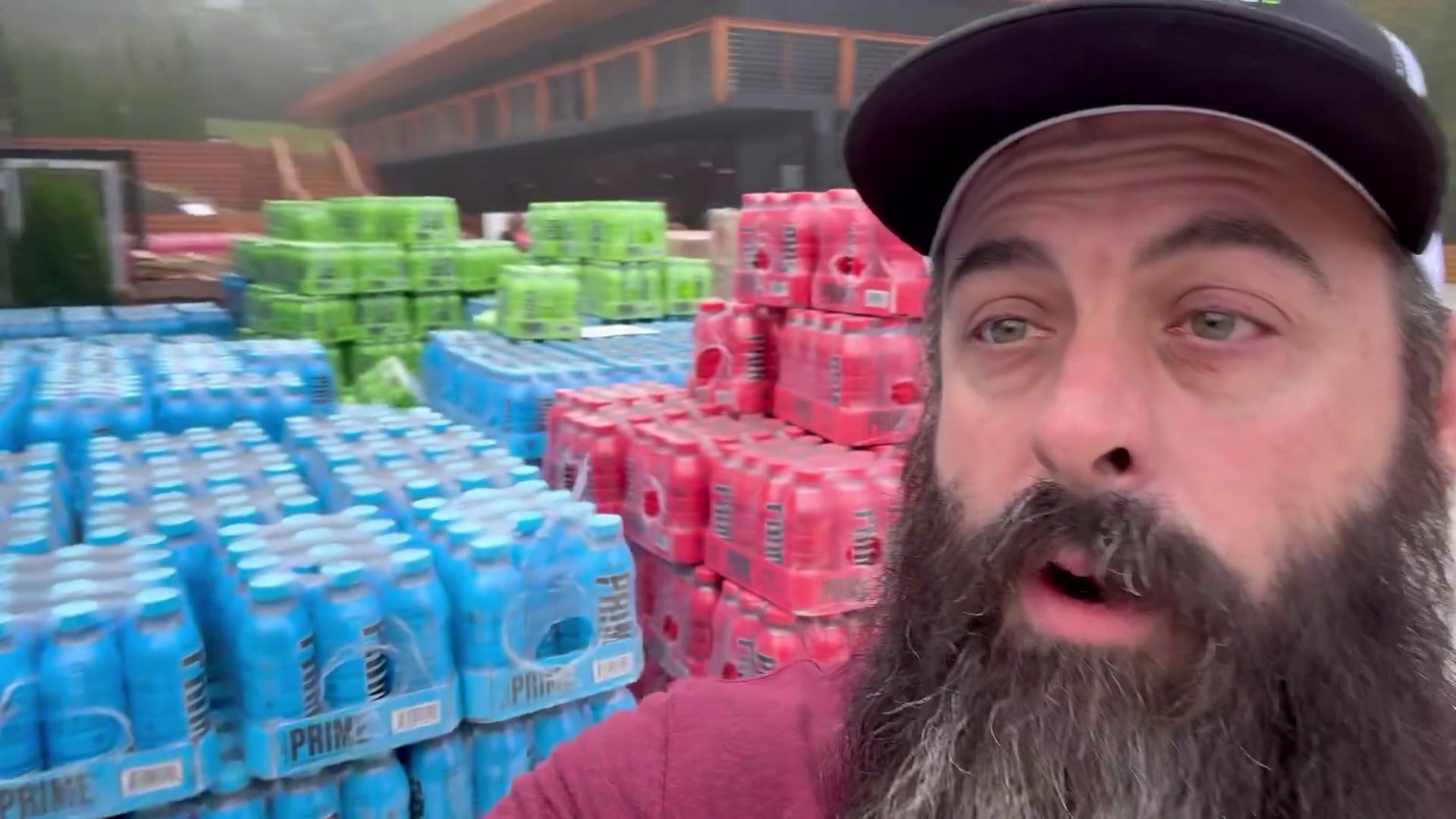 Still of Shawn Hendrix taking a selfie video in front of cases of Prime drinks.