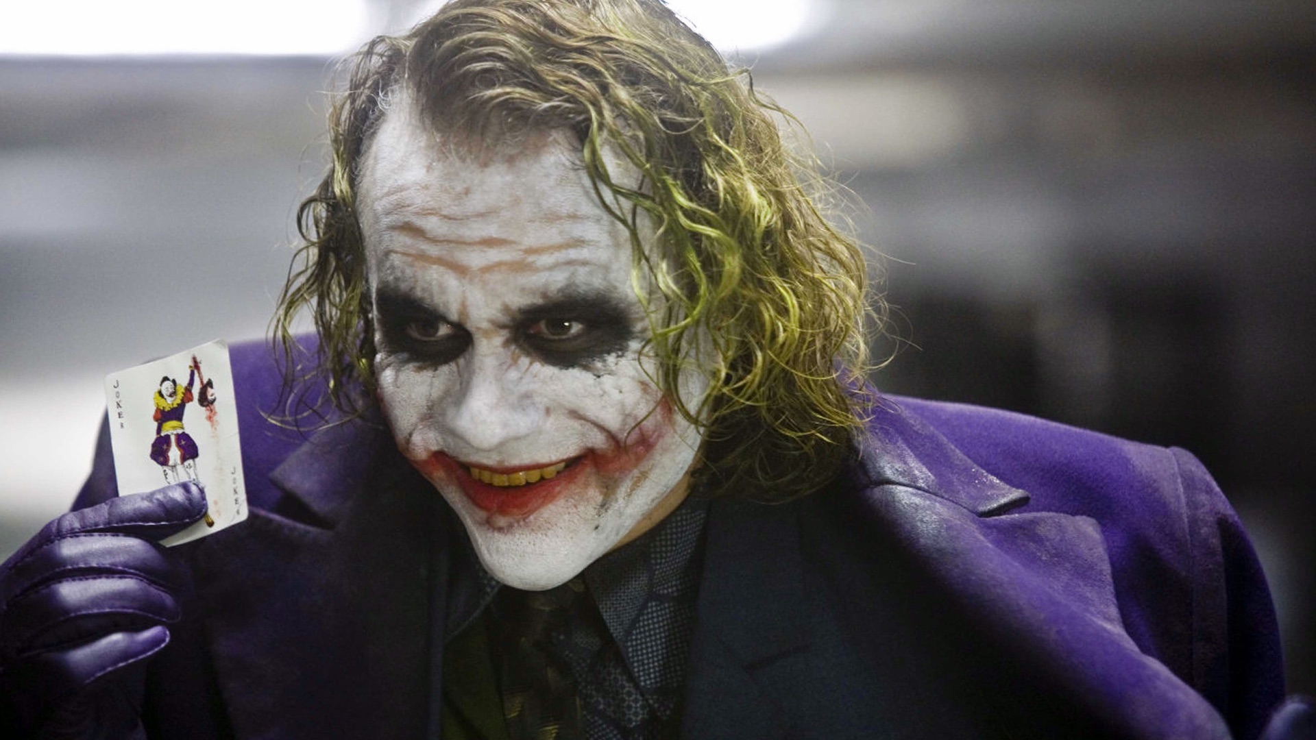 The Joker (Heath Ledger) holds up a "Joker" playing card in The Dark Night.