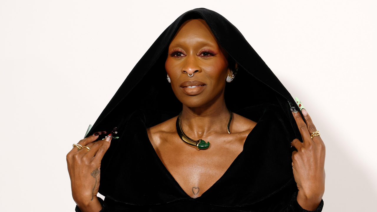 Cynthia Erivo attending the 2024 CFDA Awards at American Museum of Natural History on October 28, 2024 in New York City. She's wearing a black hooded outfit, showcasing jewelry and elaborate nails.
