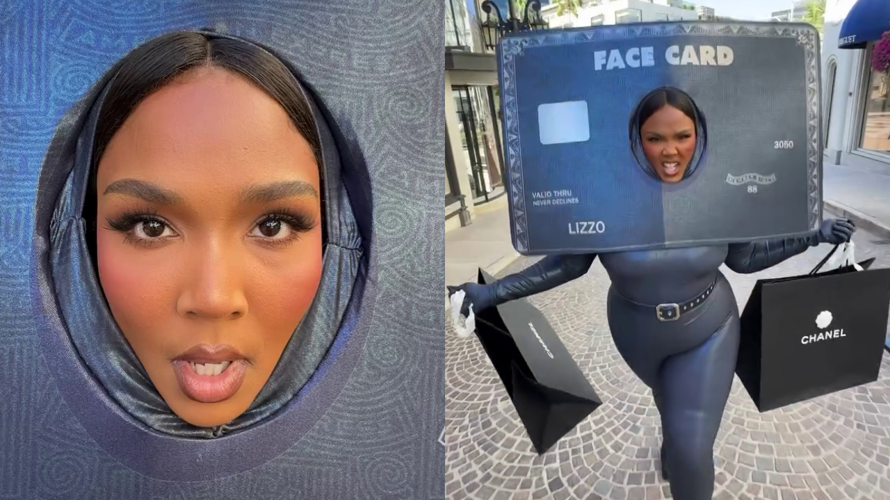 Lizzo dressed as a credit card, with her face framed in the card's cutout, holding Chanel shopping bags on a street.