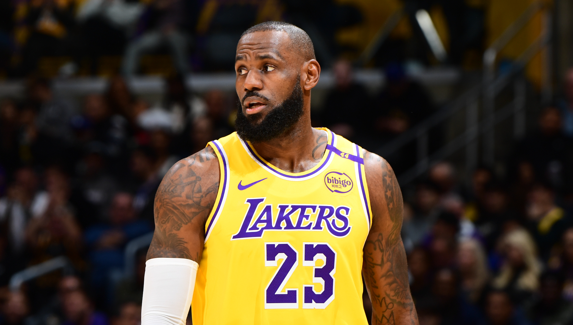 LeBron James in a Lakers jersey on a basketball court, looking to the side during a game.