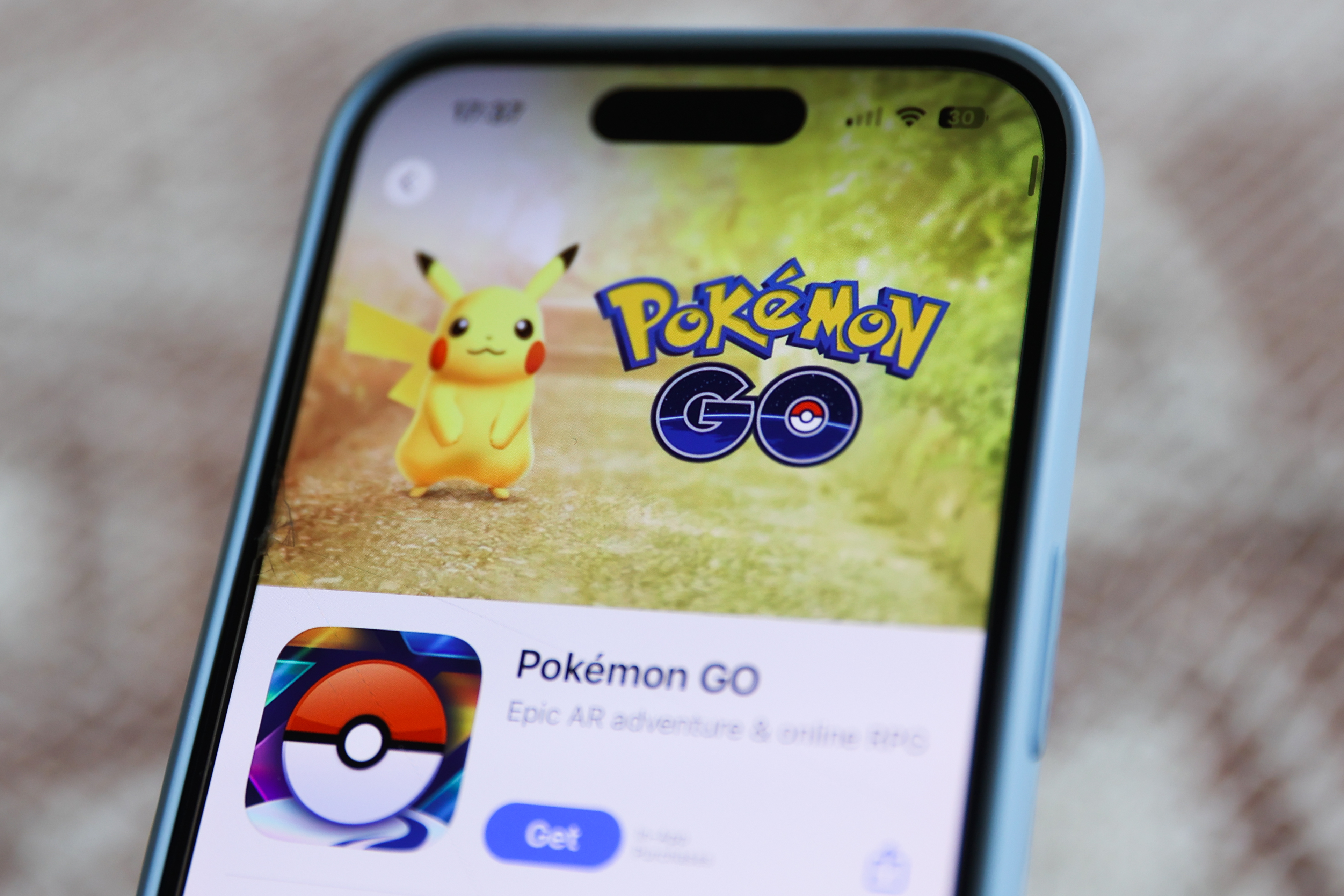 A smartphone screen displaying the Pokémon GO app page, featuring Pikachu and the app's logo