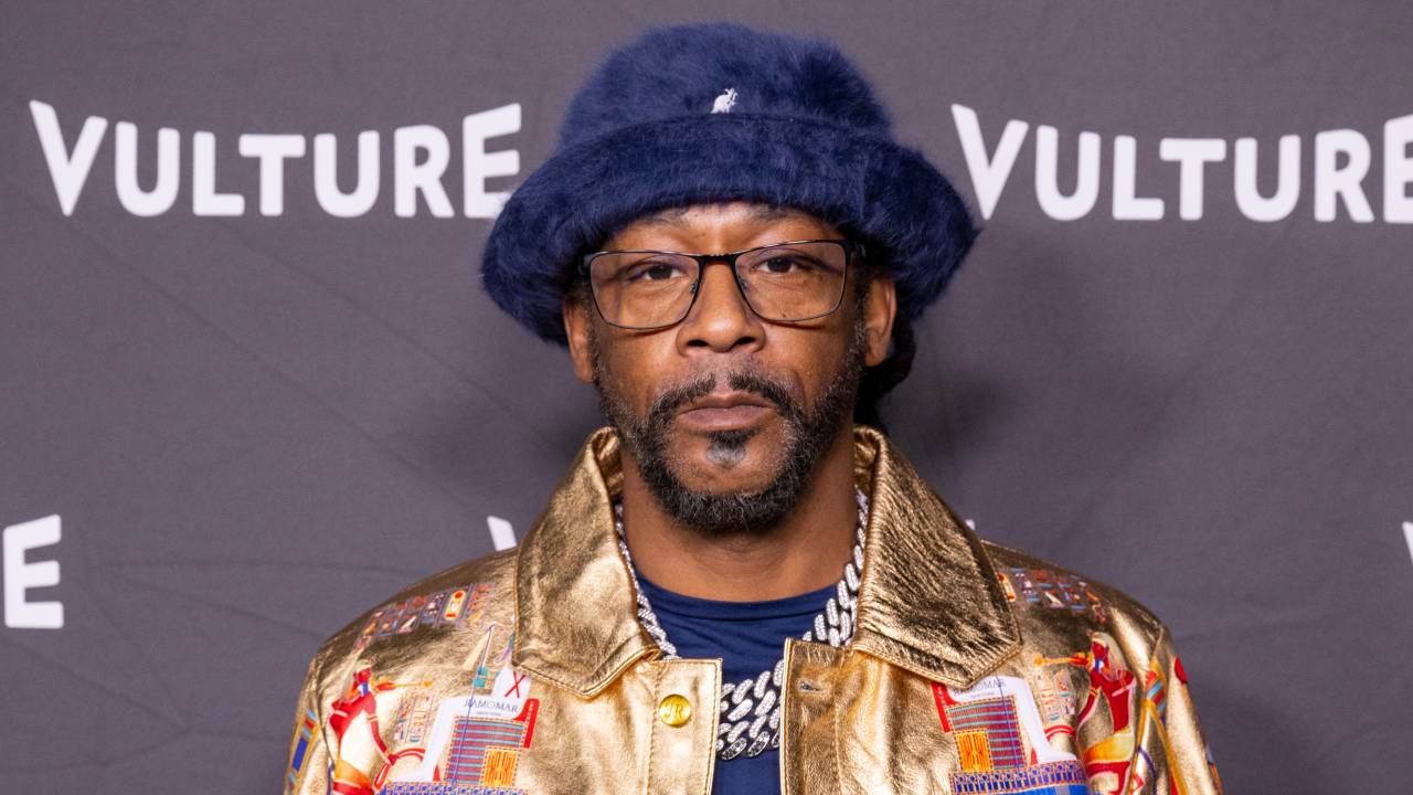 Katt Williams wearing a blue hat and gold jacket at a Vulture event.