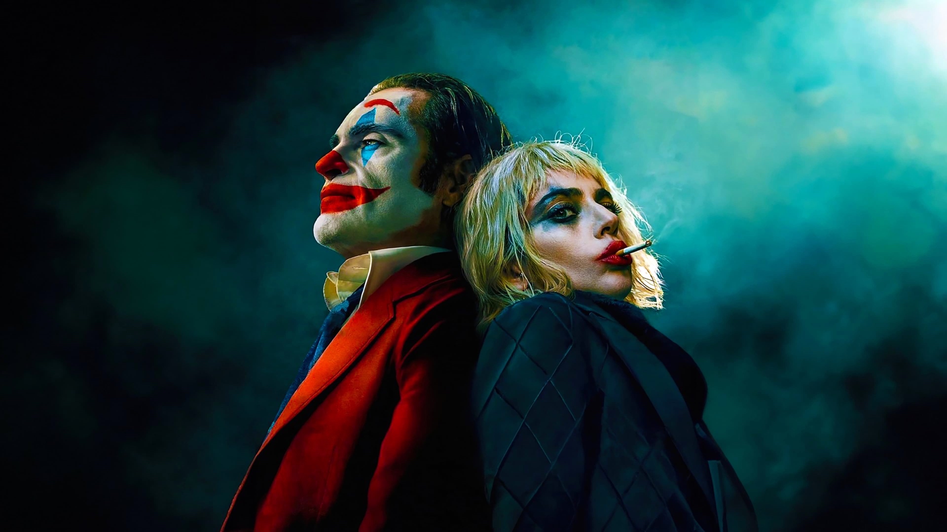 Arthur "Joker" Fleck (Joaquin Phoenix, left) Harleen "Lee" Quinzel (Lady Gaga, right) pose against a blue-and-black background for Joker: Folie à Deux.