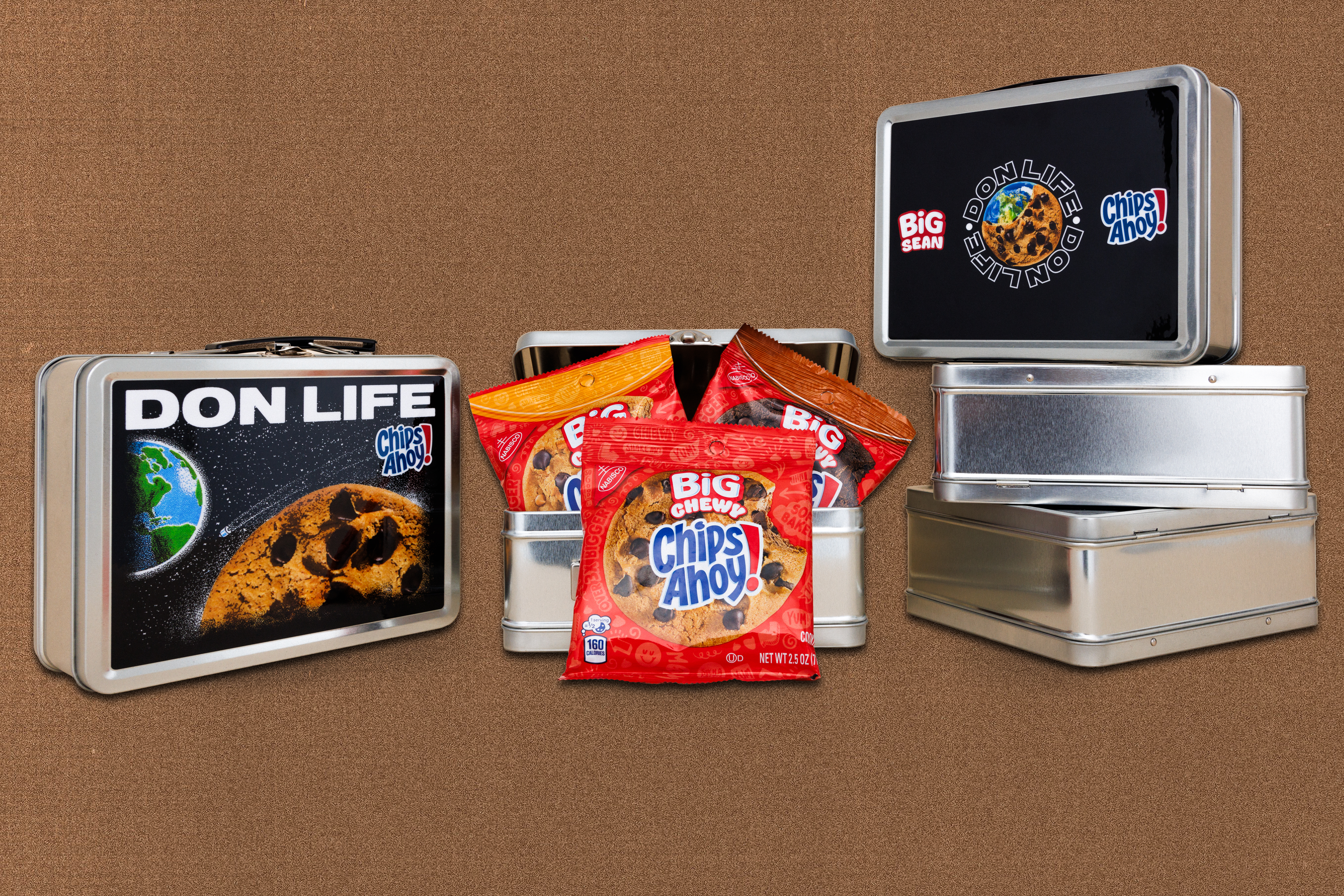 Stacks of metal lunchboxes with "DON LIFE" and "Big Sean" logos, filled with Chips Ahoy! cookie packs.