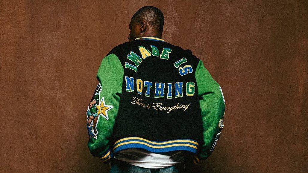 A person is wearing a colorful varsity jacket with the words "IMAGE IS NOTHING" and "This is Everything" on the back.