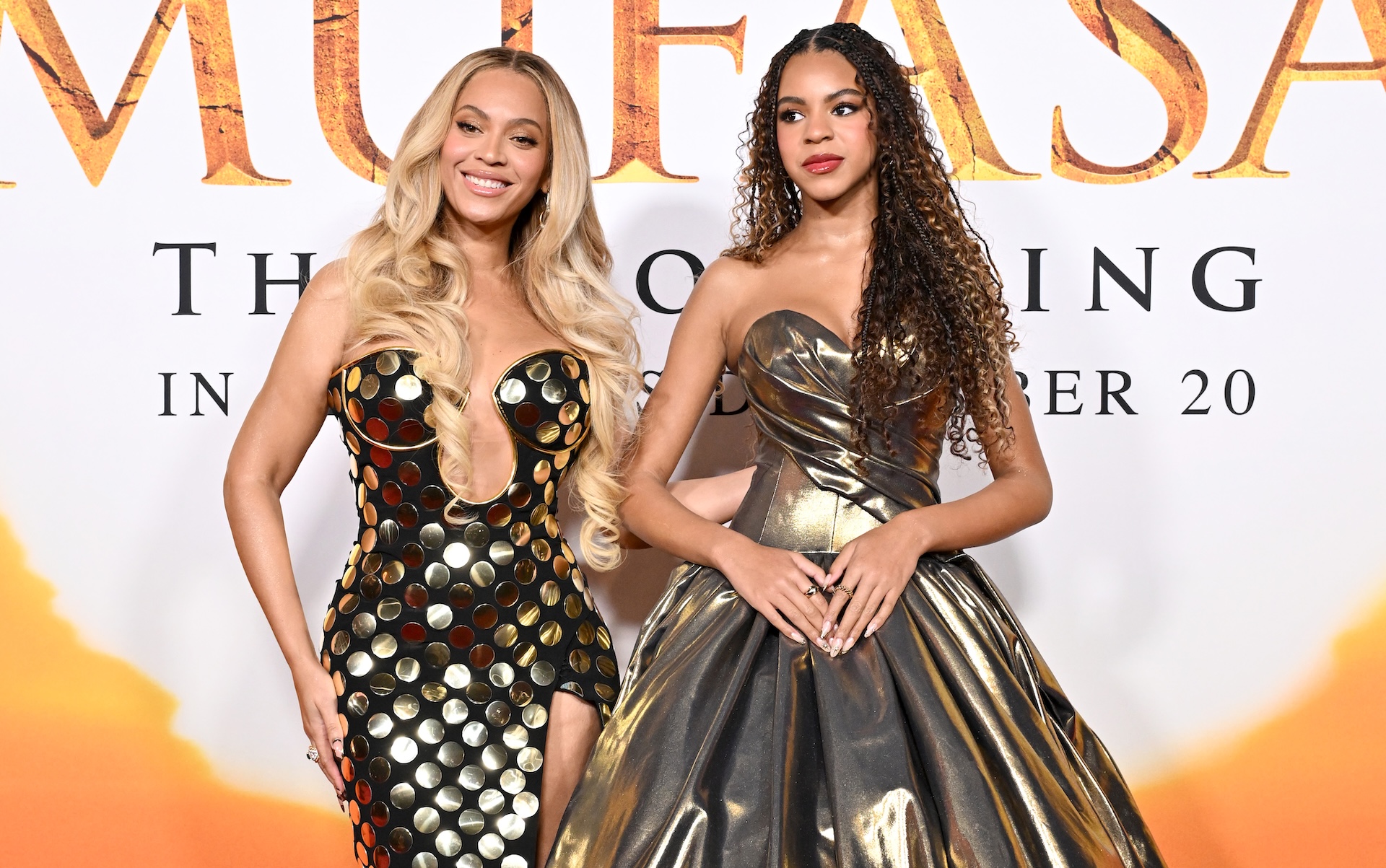 Beyoncé and her daughter Blue Ivy Carter at the premiere of "Mufasa." Beyoncé wears a metallic dress, and Blue Ivy wears a silver gown.