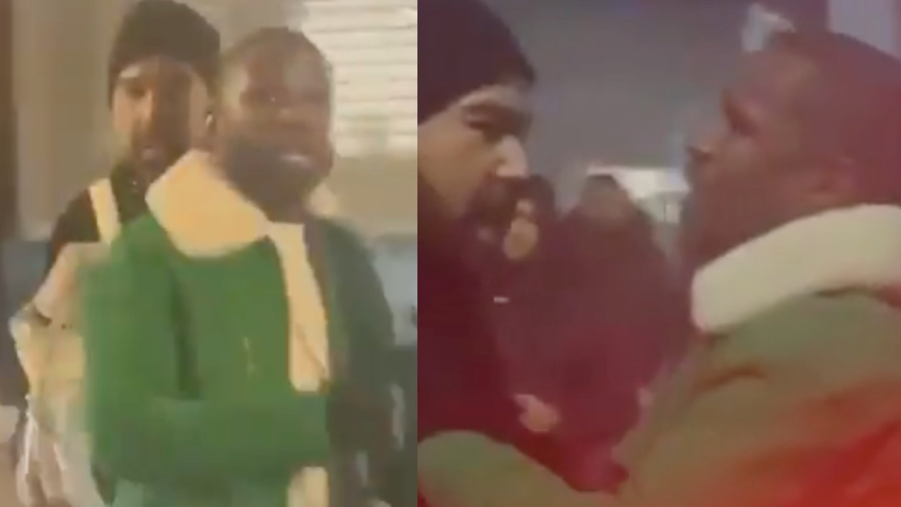 Two men in a confrontation, wearing winter jackets. The scene appears tense and indoors, with a crowd in the background.