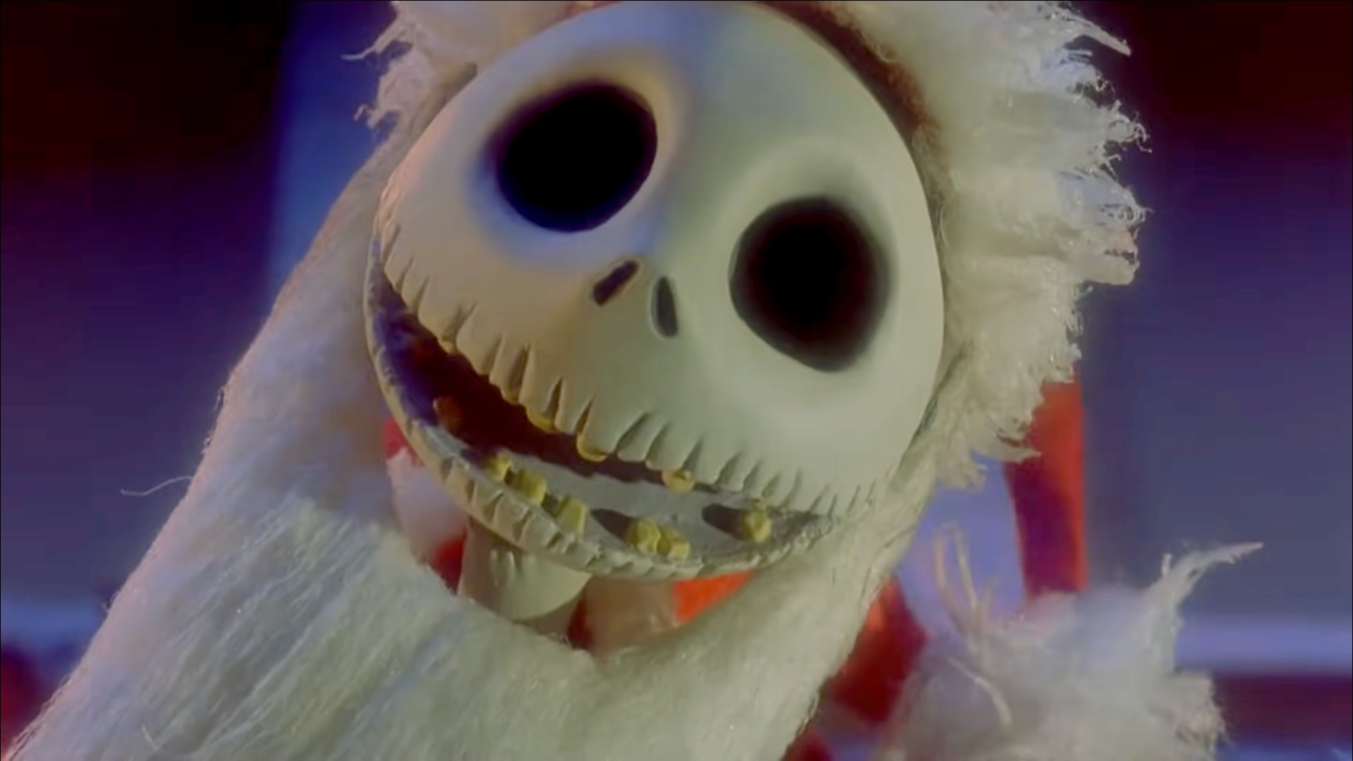 Jack Skellington smiles at the camera while wearing Santa Claus' red garb in Tim Burton's The Nightmare Before Christmas.