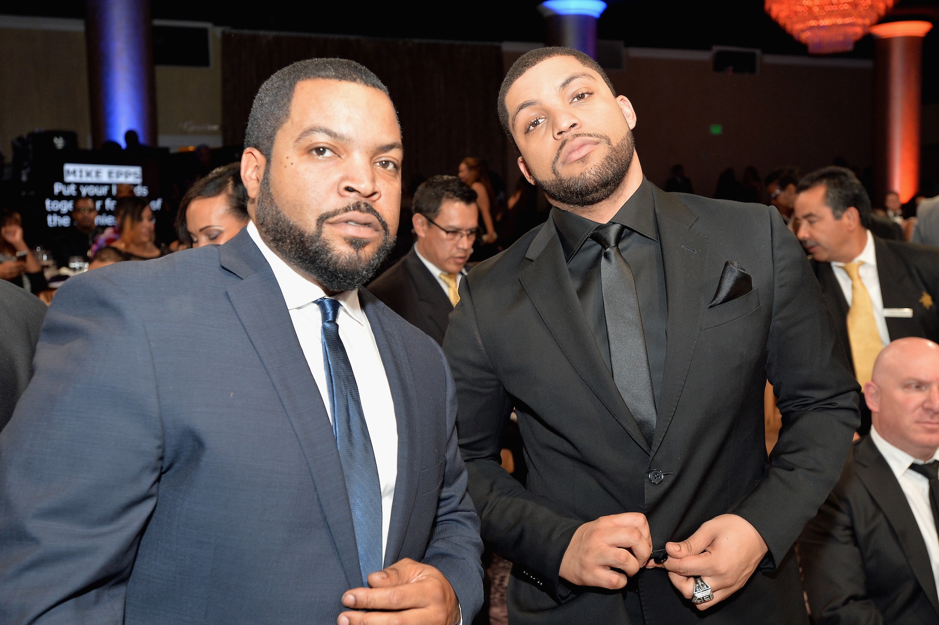 Ice Cube and O'Shea Jackson Jr. are dressed in suits at an event, posing together.