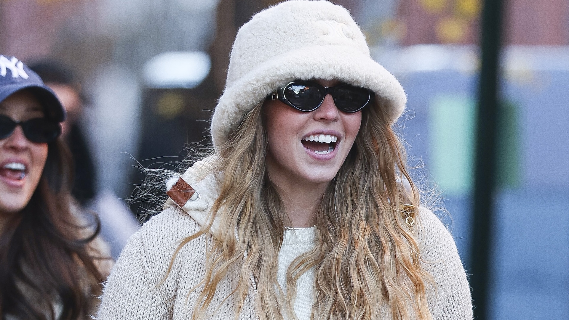 Sydney Sweeney wearing a white bucket hat and sunglasses.
