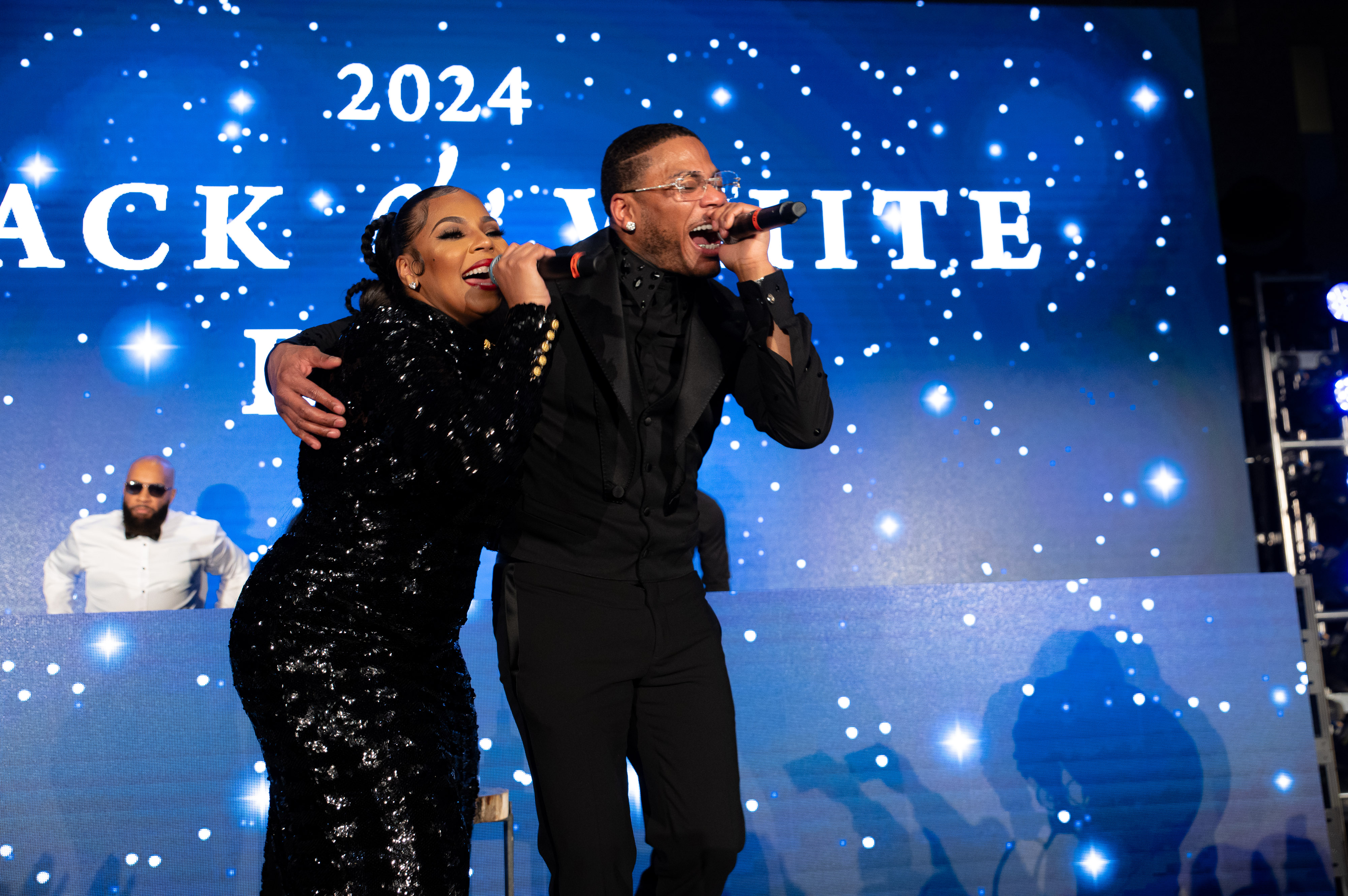 ST LOUIS, MISSOURI - DECEMBER 15: Ashanti and Nelly share a moment on stage at Nelly’s Black and White Ball on December 15, 2024 in St Louis, Missouri. 