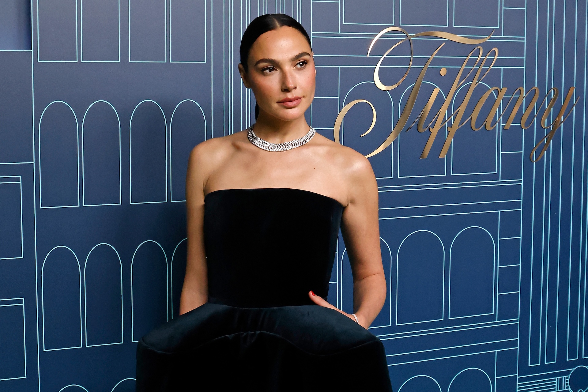Gal Gadot in a strapless black dress and diamond necklace at a Tiffany event.