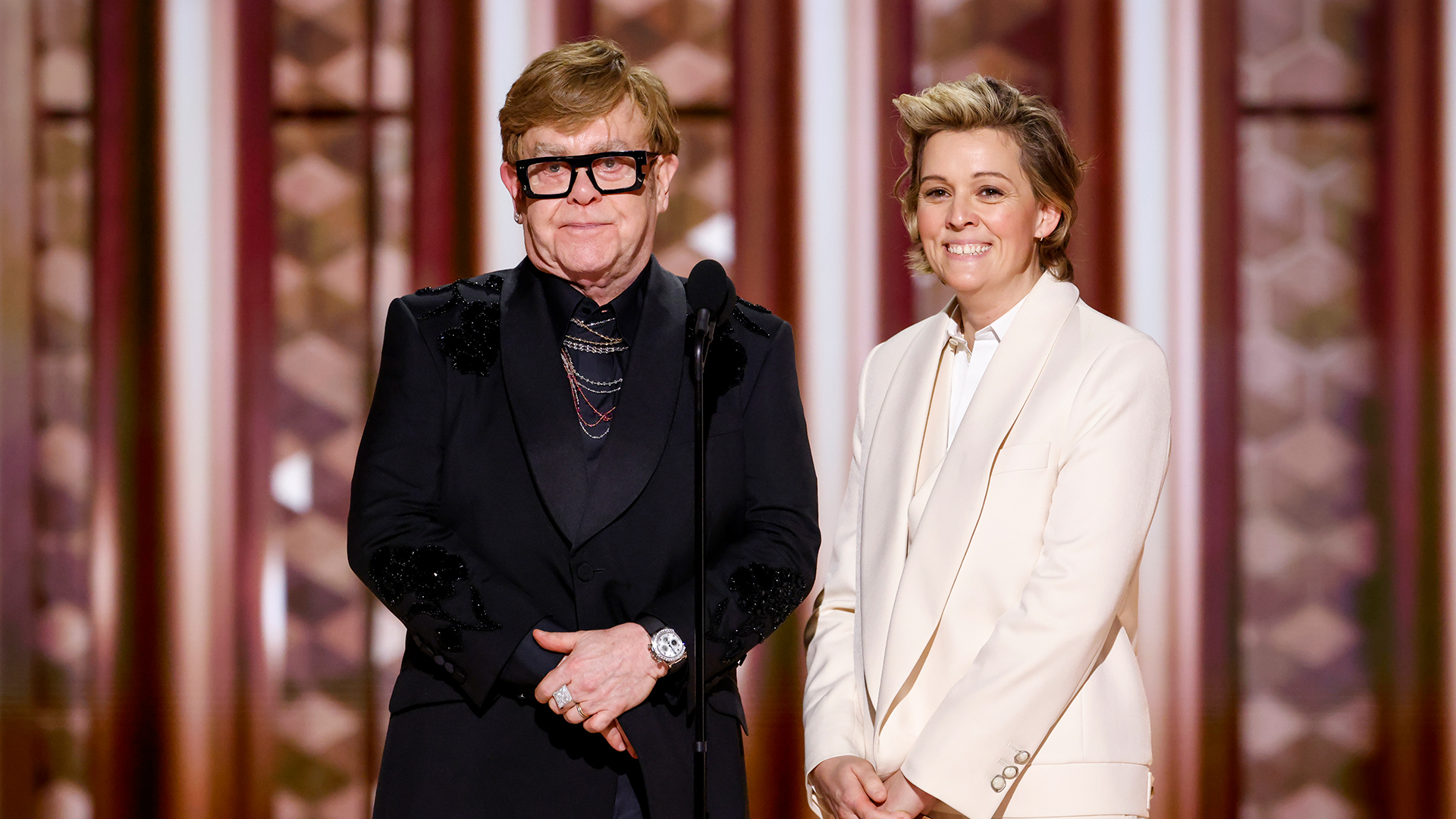 Elton John and Brandi Carlile speak onstage at the 82nd Annual Golden Globe Awards.
